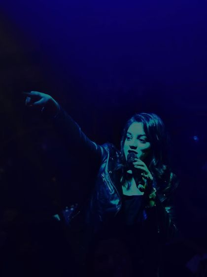 A moody, blue-lit shot of me pointing to the crowd during the Muzaffarnagar show.