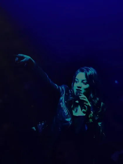 A moody, blue-lit shot of me pointing to the crowd during the Muzaffarnagar show.
