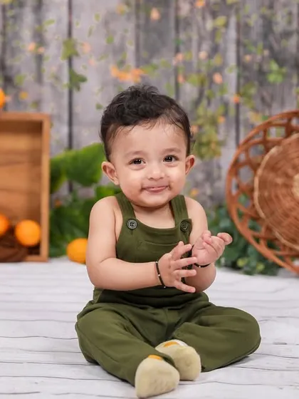 A happy clap from this little one during his sitter session. We use simple, natural-themed backdrops to create beautiful and classic portraits.