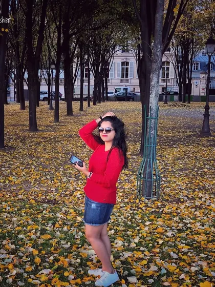 Autumn in Paris. A bright red sweater and denim skirt create a classic, chic look for exploring the city.