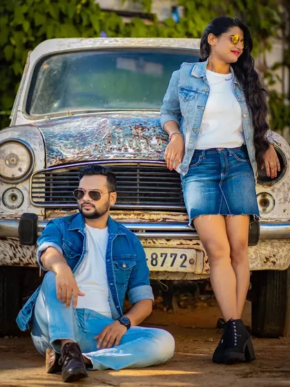 A fashionable couple poses against a classic Ambassador car, blending modern style with vintage charm. We are always looking for unique props and backdrops for your shoot.