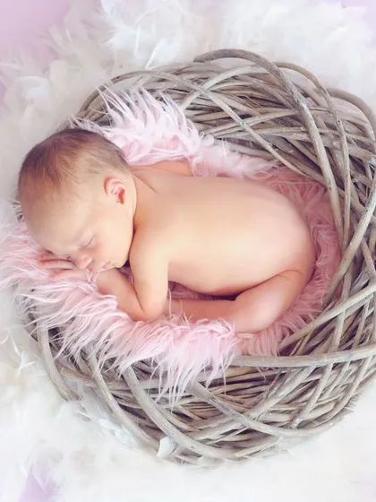 There is nothing more peaceful than a sleeping newborn. For this studio newborn session, I used a soft, nest-like prop to create a safe and cozy environment, allowing me to capture this baby's serene expression and delicate features.