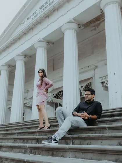 A modern, stylish pose on the grand steps of the Asiatic Society Library, using the strong lines of the pillars to create a powerful and elegant pre-wedding photograph.