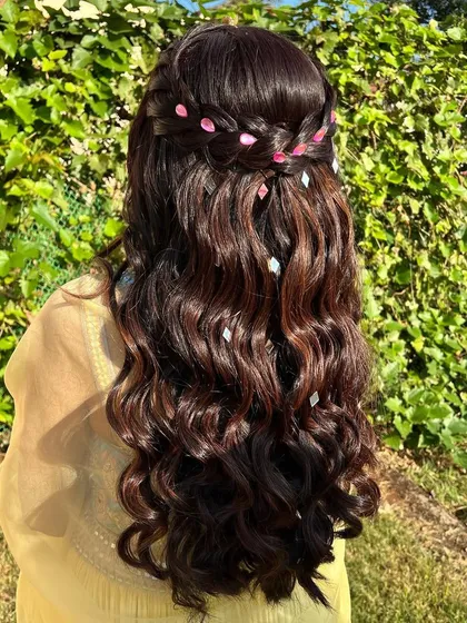 Shine bright like a diamond. This simple half-up hairstyle with a waterfall braid is elevated with small, diamond-shaped accessories scattered through the waves.