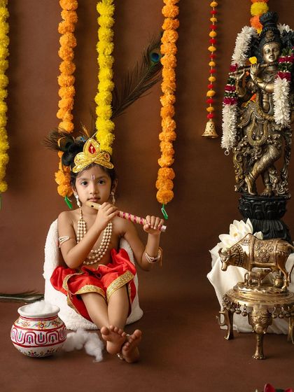 An older child poses thoughtfully with a flute, dressed as Krishna, showcasing the versatility of the theme for different age groups.