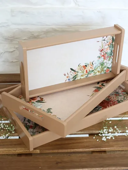 A set of three nested trays in a neutral tone with a delicate floral print. These are perfect for serving, organizing, or creating a cohesive look throughout your home.