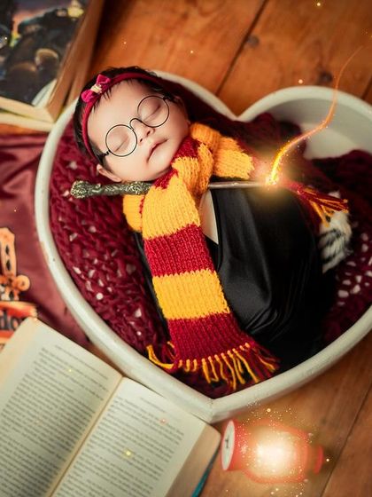 This wide shot shows the full Harry Potter set, complete with a Gryffindor banner and open spellbooks. It’s a fun way to incorporate your own passions into your baby's first photoshoot.