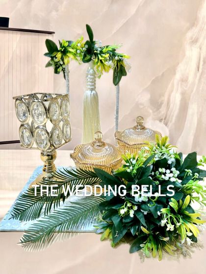 This elegant Diwali hamper combines gold crystal jars, a candle holder, and lush green foliage for a fresh and luxurious look.