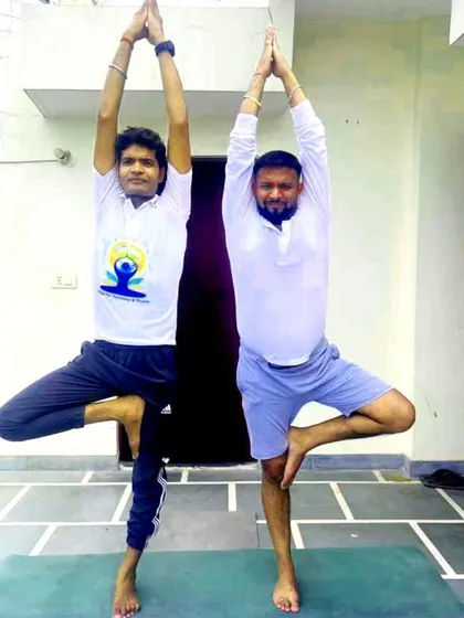 Partnering with a client for Vrikshasana. I often work alongside my students to help them find balance and confidence.