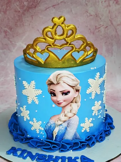 A beautiful Frozen cake with a chocolate truffle flavor. This design features a golden fondant crown and delicate snowflakes, perfect for Queen Elsa fans.