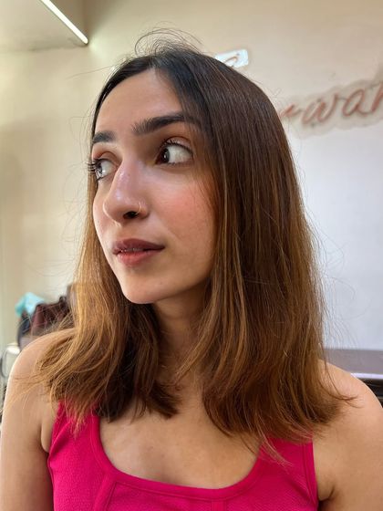 The "before" shot for a red hair makeover. The client's previous color has faded, making it the perfect base for a new, vibrant red.