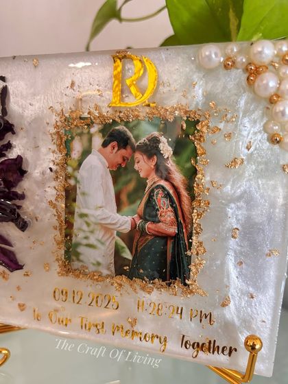 A closer look at the lotus preservation frame, showing the detail of the gold leaf border around the photo and the delicate placement of pearls. The piece is displayed on a stand, making it a perfect decorative item for a side table or mantel.