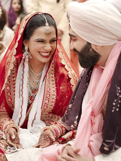 A moment of pure, uninhibited laughter between the bride and groom during their Anand Karaj ceremony.