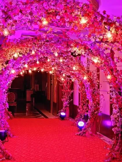 Another view of the stunning floral entrance tunnel, this time illuminated with vibrant pink lighting. The effect is glamorous and sets an exciting tone for a night of music and dance.