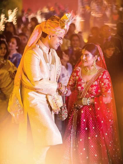 The bride and groom share a special moment during their Varmala ceremony, surrounded by the warm, ambient light of their wedding.