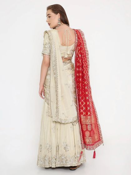 The back view of the ivory and red Bandhani lehenga, showing the delicate tie-back blouse. This is grace with a touch of desi sass.