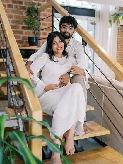 Using the staircase in their home for a portrait adds a lovely architectural element. This pose feels natural and relaxed, showcasing the couple in their multi-level home.