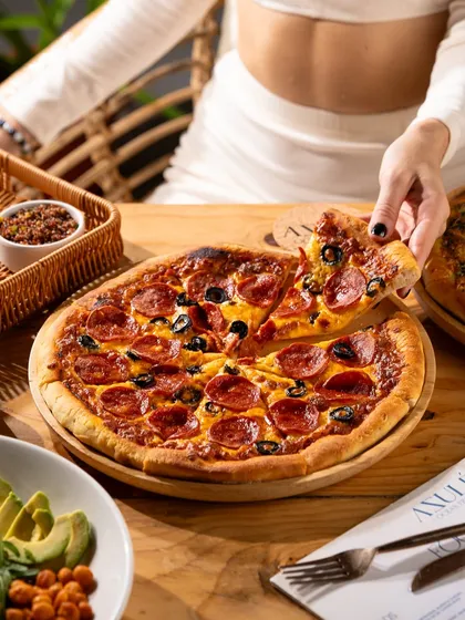 That classic pepperoni pizza cheese pull. This is a lifestyle shot that feels authentic and instantly relatable, capturing the joy of sharing a great meal.