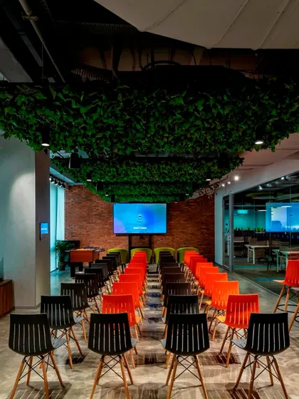 A training area or town hall space with a ceiling covered in a dense canopy of artificial leaves. This creates a unique, sheltered feeling, perfect for focused events.