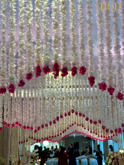 Looking up at the canopy of hanging flowers that form the archway, creating a dreamy, immersive experience for anyone walking through the entrance.