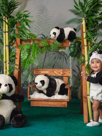 Can you spot the real panda? A little one stands proudly next to his bamboo swing in our fun panda-themed studio.
