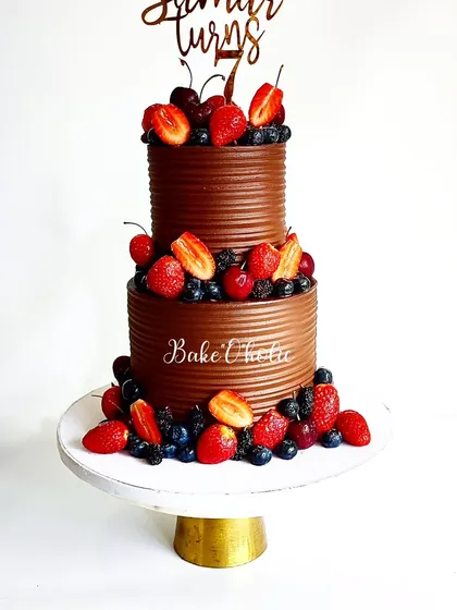 This two-tier chocolate cake, loaded with the freshest seasonal berries, is for those who love pure, simple decadence. It showcases my signature sharp-edged ganache finish, proving that a cake can be both stunning and incredibly delicious without heavy fondant.