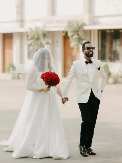 Renita and Richard take a walk after their ceremony. The bride's veiled face and the groom's confident stride create a stylish, editorial feel, blending classic wedding elements with a modern attitude.