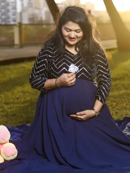 Using simple props like a teddy bear can add a touch of sweetness to your maternity photos. This shot combines a beautiful gown with a personal item, hinting at the nursery waiting at home.