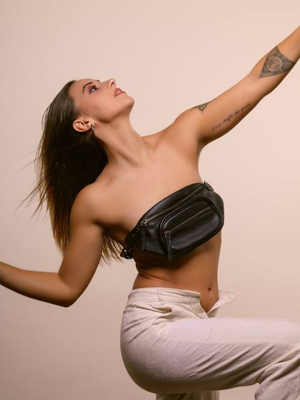 A dynamic pose with arms raised, adding a sense of freedom and movement to this artistic series.