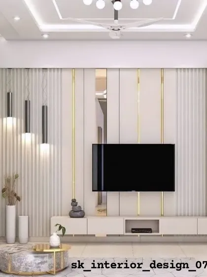 A living room TV unit featuring white fluted panels and gold-toned metallic strips. The design includes a floating console and an open shelf for display.