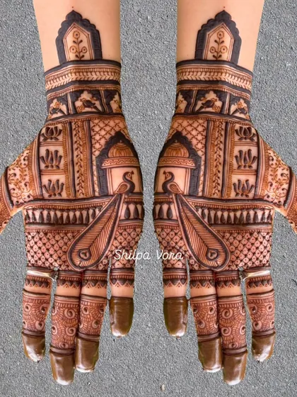 A symmetrical design featuring peacocks inside jharokhas, with intricate patterns filling the rest of the hand.