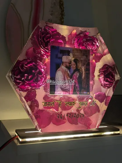 This hexagonal piece is actually a night lamp. It preserves beautiful pink roses and a photo, and the wooden base lights up to create a warm glow.