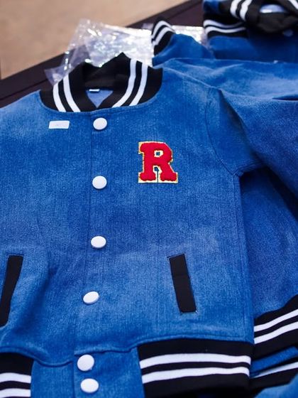 Custom-made denim varsity jackets with personalized initials, a very cool and unique party favor for the guests.
