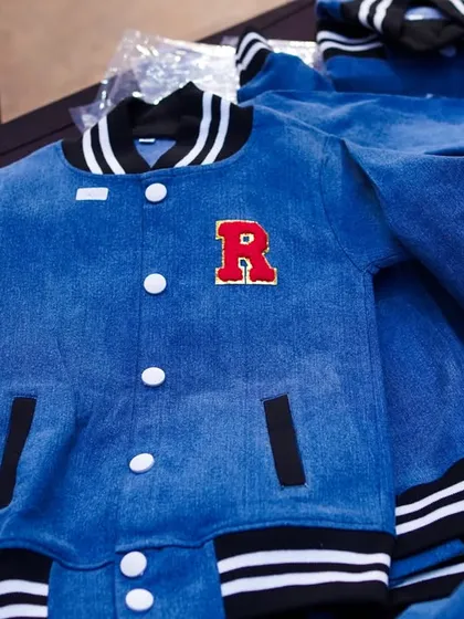 Custom-made denim varsity jackets with personalized initials, a very cool and unique party favor for the guests.