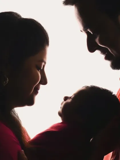 A beautiful silhouette of parents admiring their newborn baby, creating an artistic and emotional family portrait.