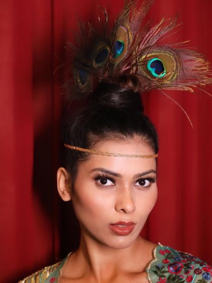 A creative peacock-feather bun styled by our students backstage at fashion week. This shows their ability to work on avant-garde and thematic hairstyles.