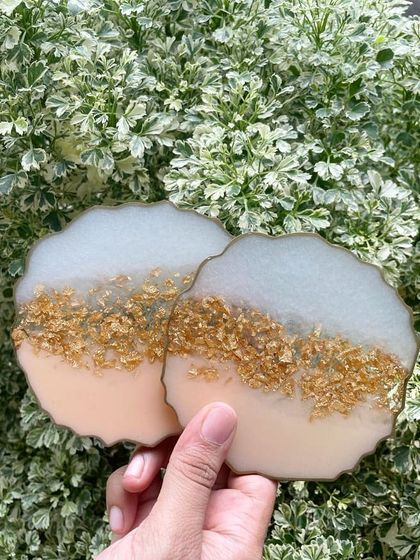 These coasters feature a soft peach and white color combination with a band of crushed gold stones. The gold edging gives them a polished, finished look.