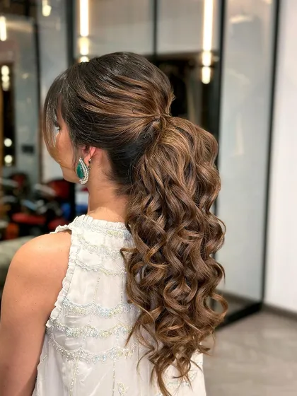 The back view highlights the texture and curls within the ponytail, showing how to create a look that is intentionally "undone" yet perfectly styled.