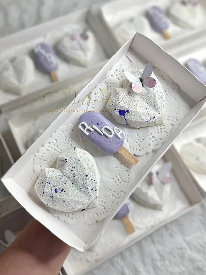A close-up of these custom return favors I made for a baby shower. The theme was lavender, so I created these geometric chocolate hearts and personalized cakesicles with the baby's name, 'Rida'. They make such a sweet thank you gift for guests.