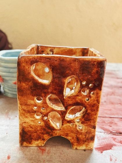 Look at these beautiful little wares from a beginner's course. She created a lovely marbled mug, a textured vase, and a carved luminary with a rich, rustic glaze.