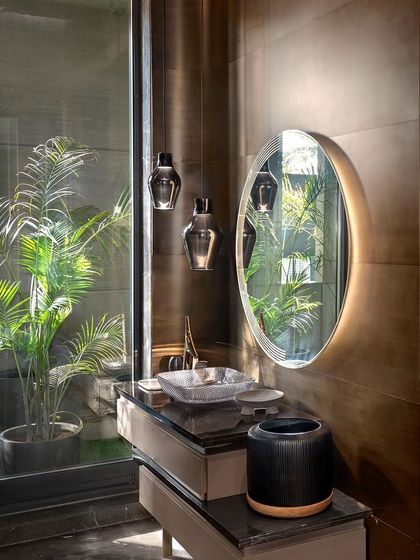 This bathroom features a large glass wall that looks out onto a private green alcove. The design brings natural light and the calming presence of plants into the space, turning a daily routine into a refreshing ritual.