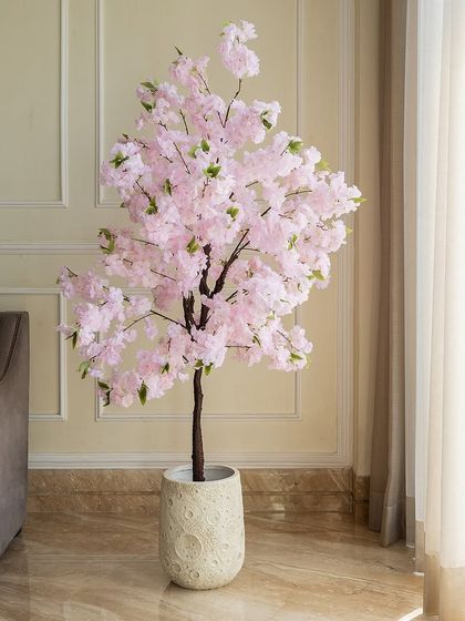 This delicate artificial cherry blossom tree brings a touch of spring indoors. The soft pink flowers create a serene and romantic atmosphere, perfect for a bedroom or living room corner.