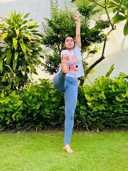 Practicing Utthita Hasta Padangusthasana (Extended Hand-to-Big-Toe Pose) in the garden. Nature provides the perfect, peaceful setting for a balancing practice.