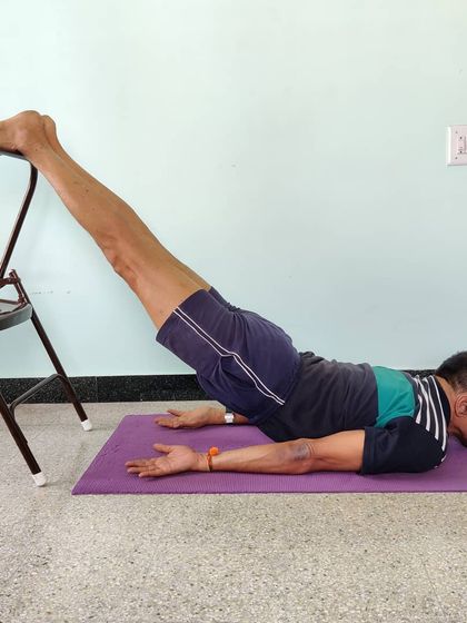 Viparita Shalabhasana (Inverted Locust Pose) with feet on a chair. This strengthens the entire back body, from the heels to the upper back.