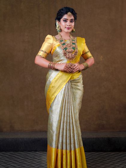 This silver and yellow silk saree creates a unique and elegant look. The draping is done to show off the beautiful contrast border and the richness of the silk.