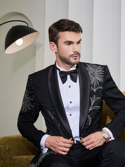 Adjusting the jacket, this pose highlights the perfect fit and silhouette of the ceremonial tuxedo. Every detail, from the shoulder to the cuff, is crafted to your measurements.