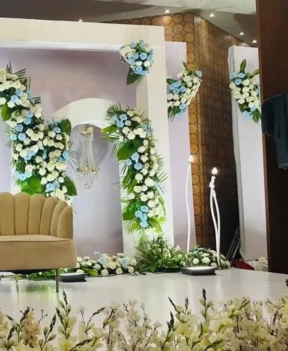 Another angle of this beautiful blue and white floral stage, highlighting the depth and dimension created by the layered arches and floral placements.