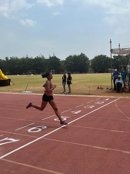 An athlete sprints to the finish, a testament to the commitment we honor in the realm of sports.