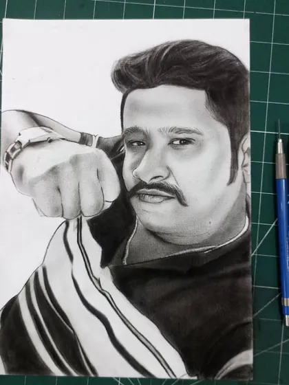 The finished portrait for a client from Karnataka, shown on my work mat next to the pencils I used to create it.