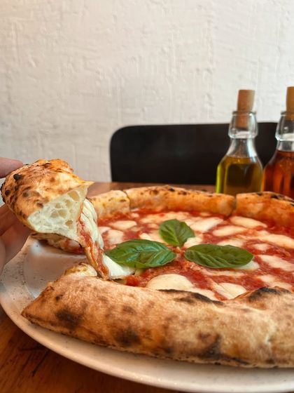 A slice of our Margherita, showing off that beautiful, airy crust. It's the perfect balance of chewy and crisp.